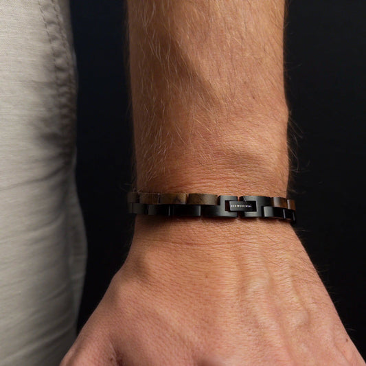 Person wearing a black bracelet on a dark background